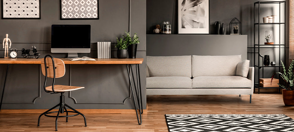 Nordic sohva valkoisella  verhoilulla olohuoneessa, huoneen etualalla työpöytä.
