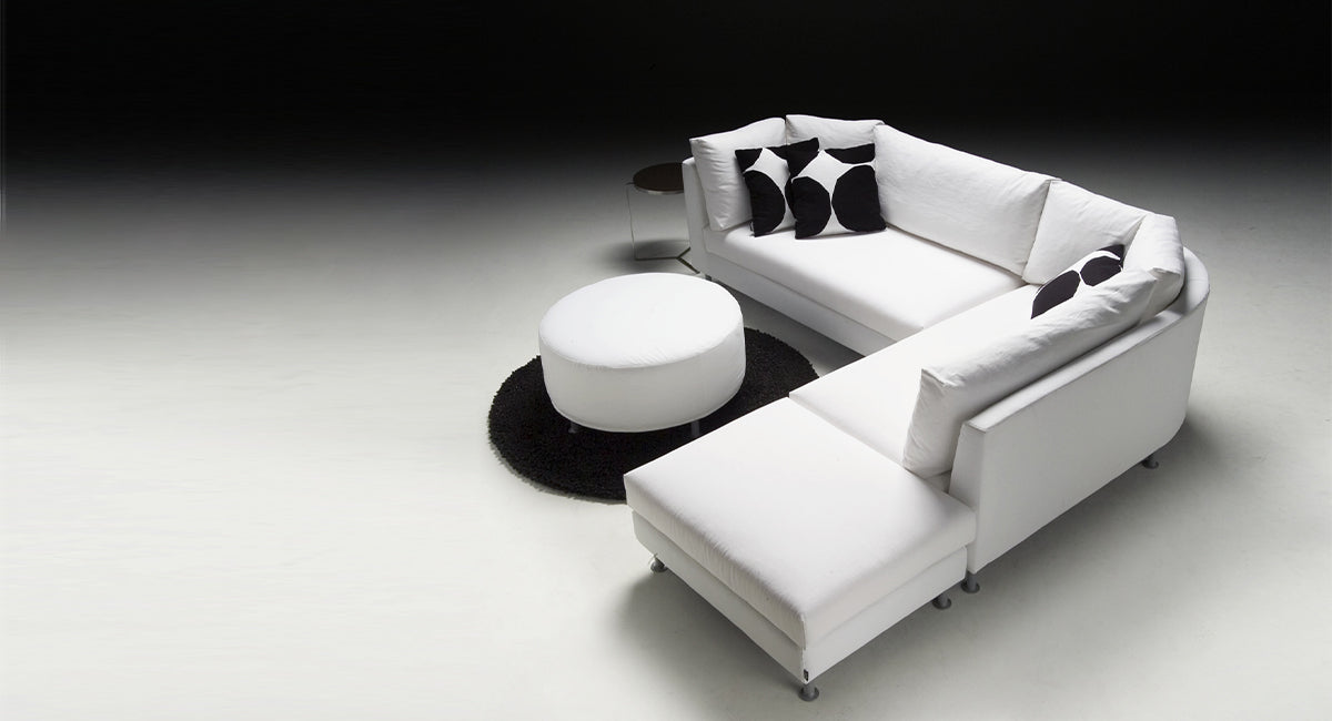 HT Collectionin Polo-kulmasohva ja pyöreä rahi valkoisella kangasverhoilulla