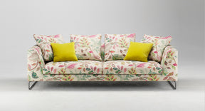 HT Collectionin Coco-sohva kangasverhoilulla, jossa vaalealla pohjalla punaisia ja vihreitä lehtikuvioita.