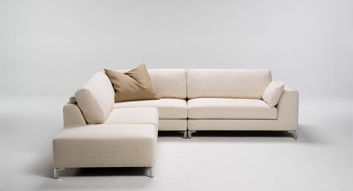 HT Collectionin Deco-sohva, välipala ja rahi vaalealla kankaalla.