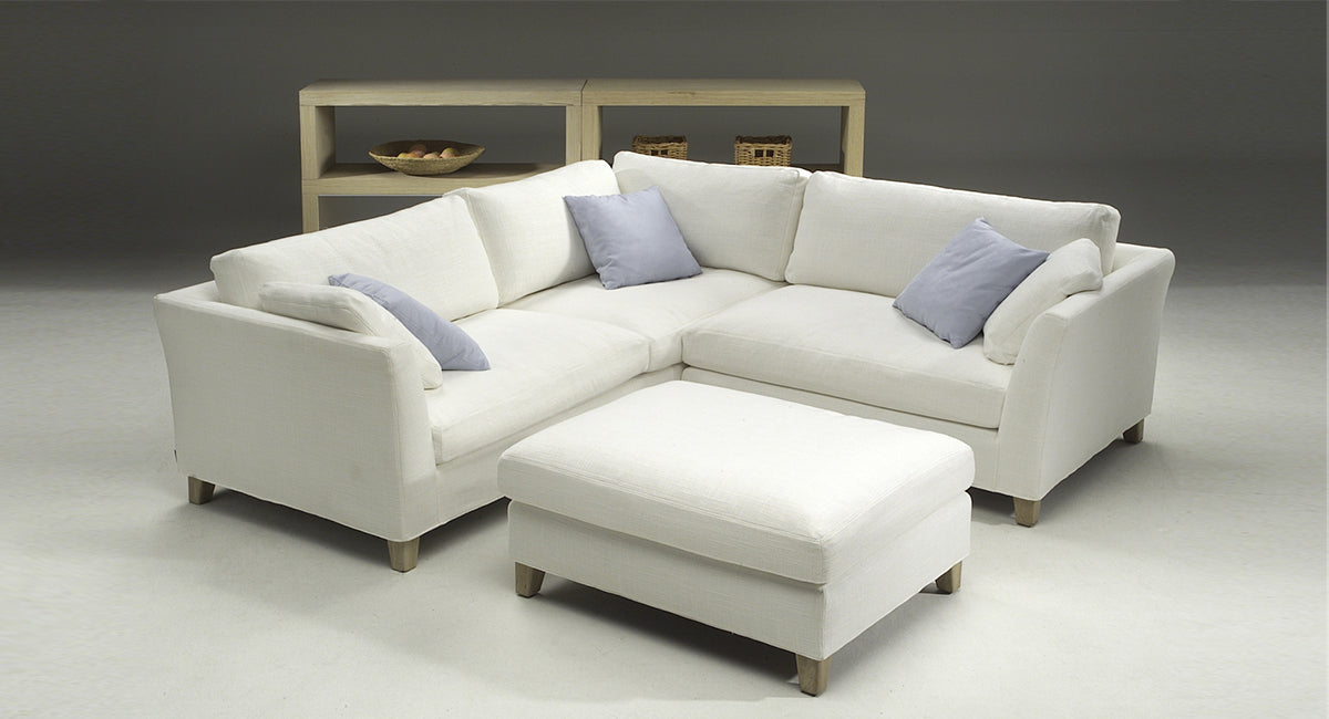 HT Collectionin Move-kulmasohva ja rahi valkoisella kangasverhoilulla