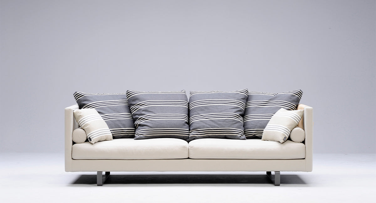 HT Collectionin Polo-sohva valkealla kagasverhoilulla ja sinisenraidallisin selkänojatyynyin
